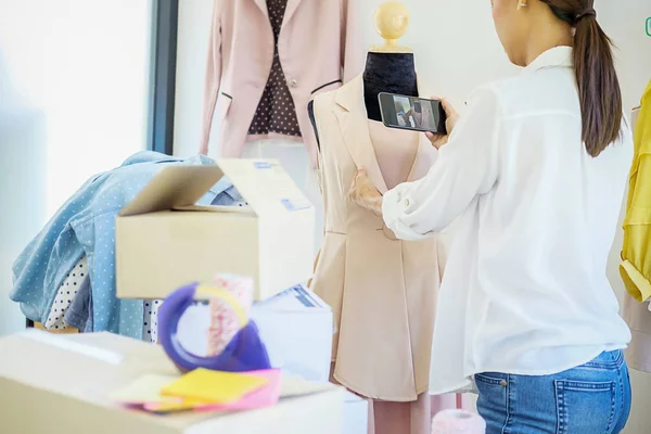 Alegre encantador jovem empresário em pé na loja de roupas — Fotografia de Stock