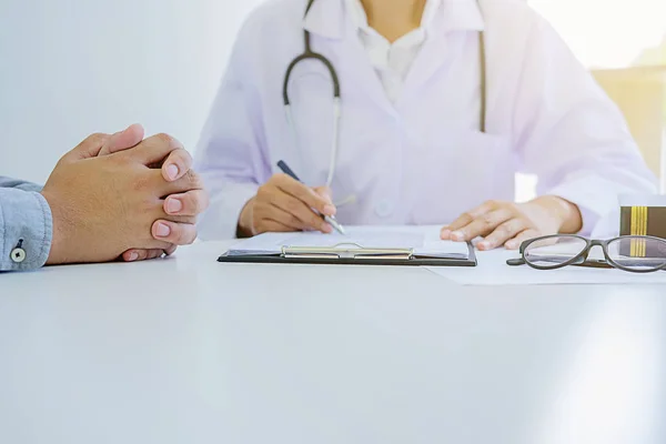 Paciente escuchando atentamente a un médico masculino explicando — Foto de Stock