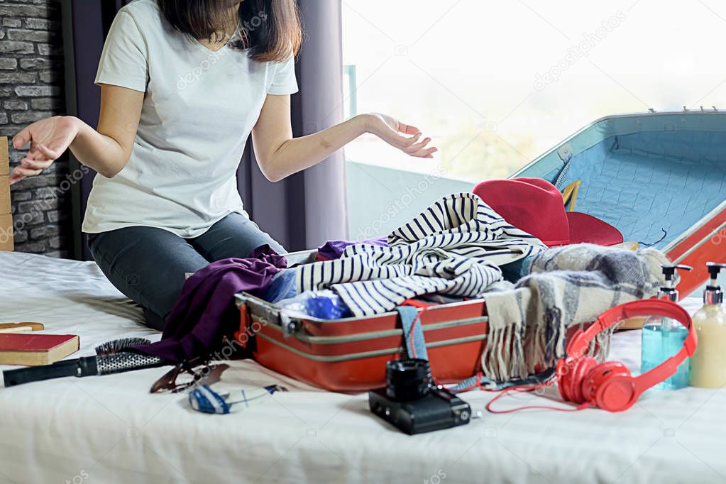 People packed suitcase with travel accessories on bed. Vacation 