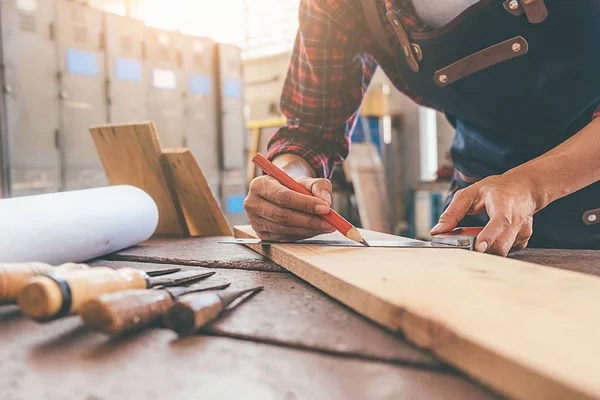 Tischler arbeitet mit Geräten auf Holztisch in Tischlerei — Stockfoto