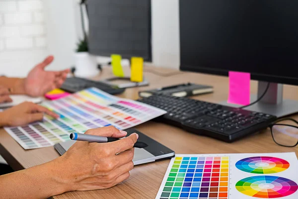 Graphic design with color swatches and tablet on a desk. Graphic