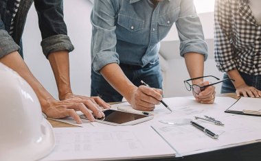 Mühendisler tartışmak bir plan üzerinde bilgi denetlerken bir ta