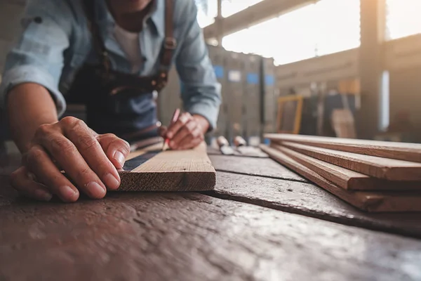 Tischler arbeitet mit Geräten auf Holztisch in Tischlerei — Stockfoto