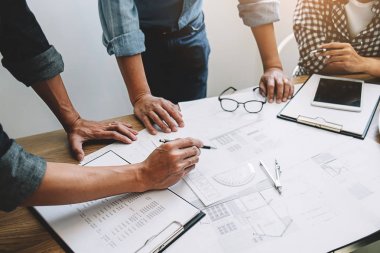 Bir ofiste bir tablet bilgisayardaki bilgileri denetlenirken bir plan mühendisleri tartışmak.