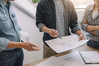 Mühendisler tartışmak bir plan üzerinde bilgi denetlerken bir ta