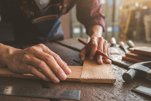 Плотник, работающий с оборудованием на деревянном столе в столярном деле — стоковое фото