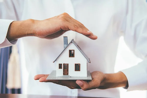 Ahorro de dinero para la casa y bienes raíces. Mujer mano protección en —  Fotos de Stock