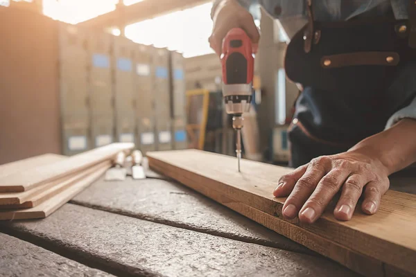Плотник, работающий с оборудованием на деревянном столе в столярном деле — стоковое фото