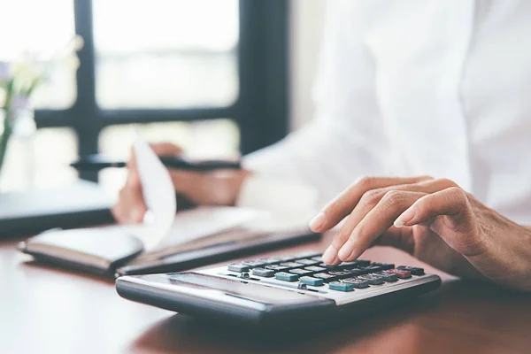 Vrouw met facturen en rekenmachine. Vrouw met behulp van de calculator voor Regelsvoororganizatie — Stockfoto