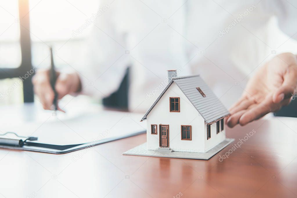 House model with real estate agent and customer discussing for c