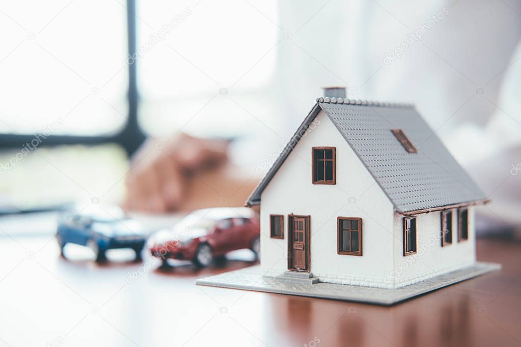 House model with real estate agent and customer discussing for c