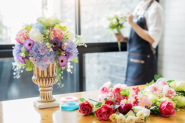 Manos de mujer haciendo composición de flores en el taller de floristería. Hazlo. — Foto de Stock