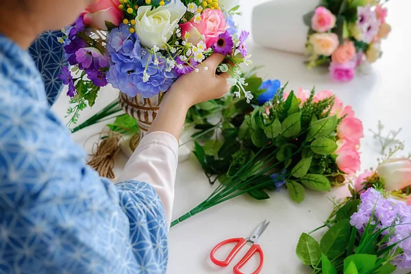 Woman hands making flower composition at florist workshop. Do it