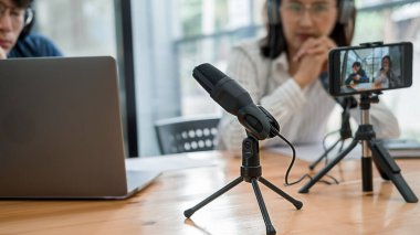 Genç iş adamları bir stüdyoda podcast kaydediyor.