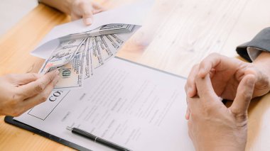 İş adamı, emlak sözleşmesi ve finans şirketi için anlaşma yaparken para veriyor. Rüşvet ve yolsuzluk kavramı