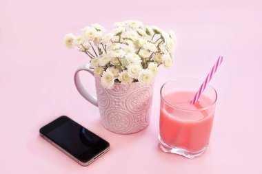 Bir fincan çay cam kokteyl telefon kasımpatı çiçeği buket. Festival pembe arka plan