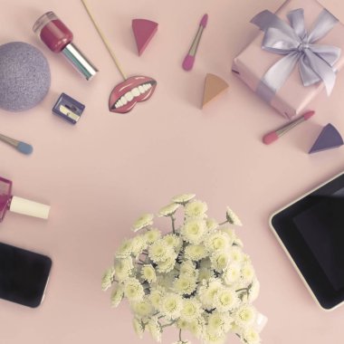 Krizantem kozmetik aksesuarları buket hediye tablet parfüm pembe bir arka plan üzerinde telefon. Üstten görünüm kopya alanı düz yatıyordu