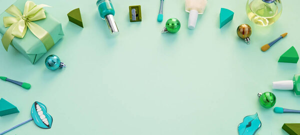 Баннер Декоративная композиция косметика подарок духи на зеленом фоне. Вид сверху Плоский плакат для вашего текста. Рождественские игрушки
