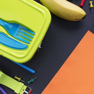 Kavram Okulu İzle muz beslenme çantası Kırtasiye siyah arka plan üzerine başa. Üstten görünüm düz yatıyordu