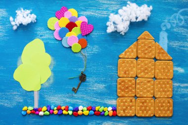 The concept of a cookie house on a wooden blue sky cloud background family path. Top view Flat lay clipart