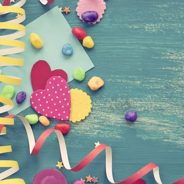 Festive confetti background heart candy color saturated. Wood old blue background with copy space flat lay