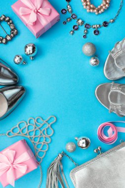 Festival kompozisyon Düz LEI bayan aksesuar takı hediye elbise ayarla çanta kolye kutusu Noel topları ayakkabılar. Üstten görünüm çerçeve mavi arka plan