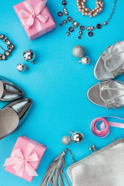 Festival kompozisyon Düz LEI bayan aksesuar takı hediye elbise ayarla çanta kolye kutusu Noel topları ayakkabılar. Üstten görünüm çerçeve mavi arka plan