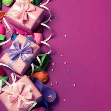 Festival arka planını Mor malzeme renkli balonlar flamalar konfeti üç kutuları hediye. Üstten görünüm düz kopya alanı tonlama yatıyordu