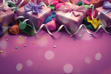 Festival arka planını Mor malzeme renkli balonlar flamalar konfeti dört kutu hediye. Üstten görünüm düz kopya alanı tonlama yatıyordu