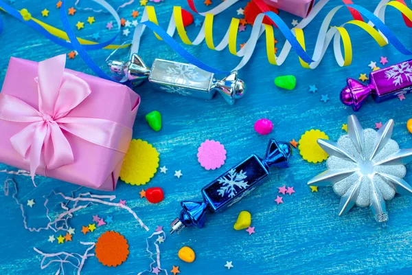 Festival parlak mavi arka plan dekorasyon tatil için konfeti serpantin kağıt hediye renkli. Üstten görünüm düz kopya alanı Noel candy kar taneleri oyuncaklar yatıyordu.