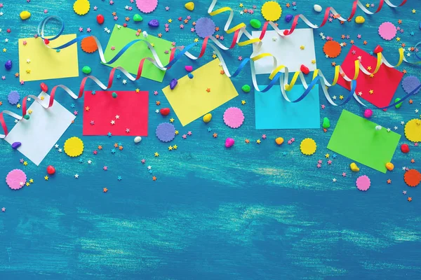 Feestelijke helder blauwe achtergrond decoratie voor vakantie gekleurde confetti serpentine papier geschenken bovenaanzicht plat lag kopie ruimte — Stockfoto