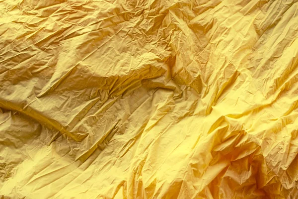 Abstracto brillante rico fondo amarillo arrugado textil desenfoque Vista superior espacio de copia — Foto de Stock