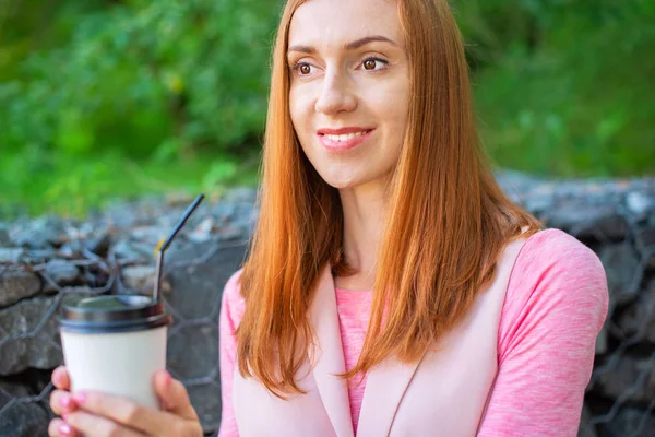 美しい赤い髪の少女は階段を下りて行くし 紙カップからコーヒーを飲みます 公園でライフ スタイル朝食 — ストック写真