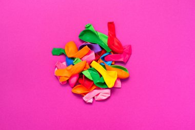 Pembe bir arka plan üzerinde renkli balonlar kümesi. Düz yatıyordu üstten görünüm