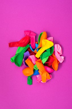 Pembe bir arka plan üzerinde renkli balonlar kümesi. Düz yatıyordu üstten görünüm