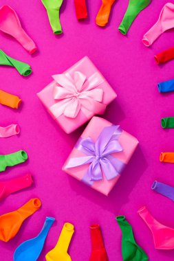 Pembe bir arka plan üzerinde renkli balonlar kümesi. Düz yatıyordu üstten görünüm