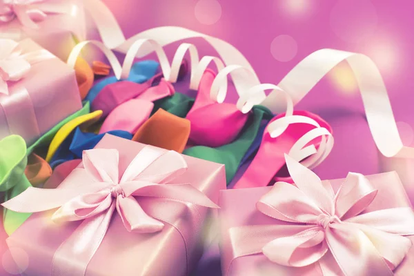 装饰盒组成与礼物缎带蝴蝶结充气球蛇形紫色背景 平房的顶部景观 — 图库照片