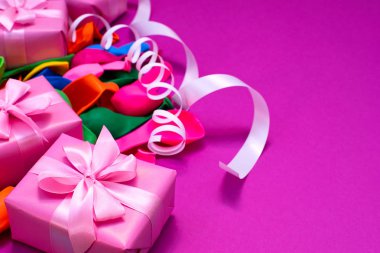 Dekoratif kutu kompozisyon hediyeler saten şerit yay Ulusal teketim ürünleri serpantin mor arka plan ile. Düz yatıyordu üstten görünüm