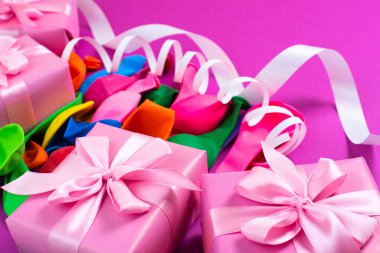 Dekoratif kutu kompozisyon hediyeler saten şerit yay Ulusal teketim ürünleri serpantin mor arka plan ile. Düz yatıyordu üstten görünüm