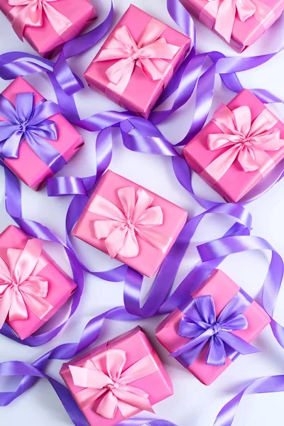 boxes with gifts for the holiday birthday Christmas Valentine\'s day pink on white background. Top view flat lay vertical. Selective focus