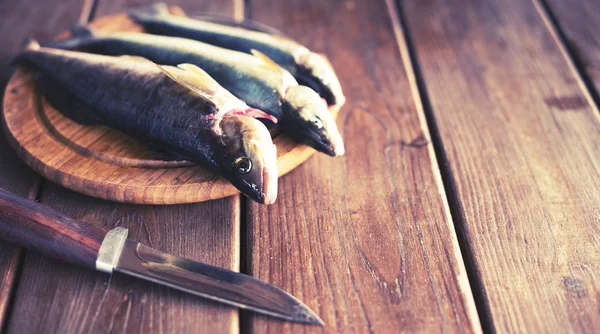 Banner αλιεύματα φρέσκα θαλασσινά ψάρια βρίσκεται σε μια κοπή σκάφους σε ένα ξύλινο τραπέζι στην κουζίνα επιλεκτική εστίαση αντίγραφο χώρου — Φωτογραφία Αρχείου