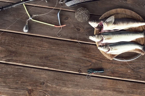 The catch of fresh sea fish lies on a cutting Board on a wooden table in the kitchen. Selective focus copy space