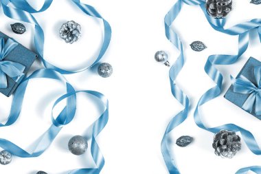 Beyaz arka plan koniler fındık dekor gümüş rengi mavi saten şerit üzerinde Noel kompozisyon. Üstten görünüm düz yatay yatıyordu