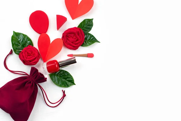 Fluwelen tas met geschenken rode rozen groene bladeren cosmetica. Het concept van de dag van Valentijnskaarten een top zicht op vlakke lay — Stockfoto