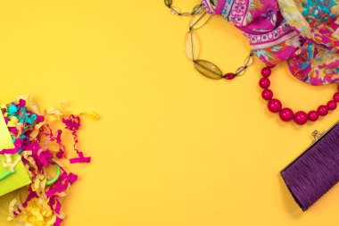 Bayan aksesuarlar düz sarı zemin üzerinde yatıyordu. Üstten görünüm kopya alanı