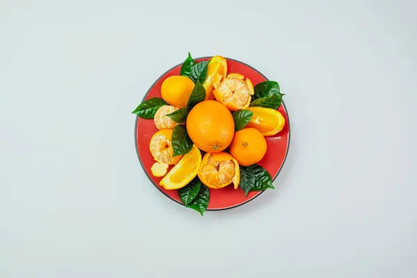 Red Plate Oranges Tangerines Green Leaves Light Background Top View — Stock Photo, Image