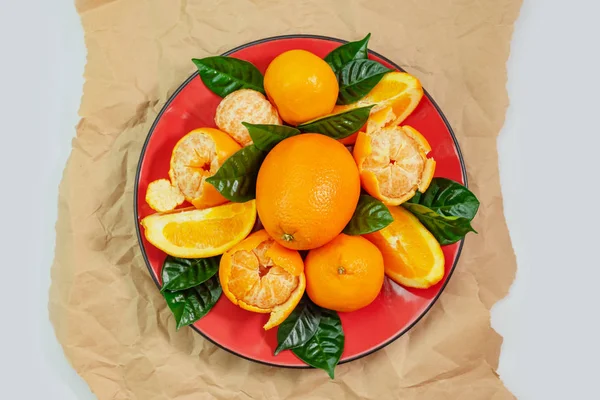Red Plate Oranges Tangerines Green Leaves Light Background Top View — Stock Photo, Image