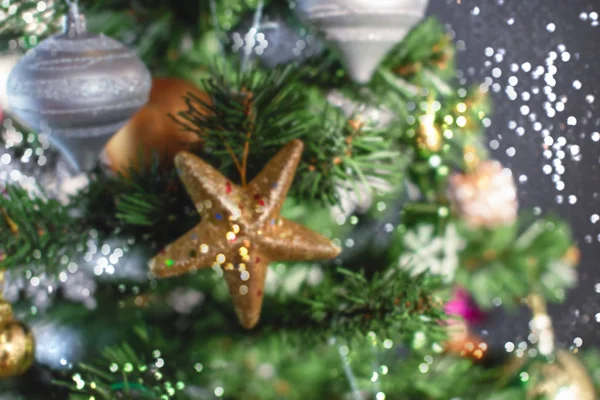 Desfocando fundo festivo árvore de Natal. Xmas decoração brinquedo bolas floco de neve cone lantejoulas estrela floco de neve . — Fotografia de Stock