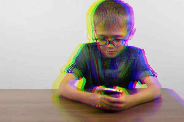 Glitch effect. Banner Hands of a boy using a mobile phone on the table at school on a white background Modern mobile and communications