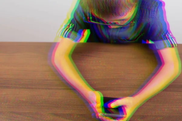 Glitch effect. Banner Hands of a boy using a mobile phone on the table at school on a white background Modern mobile and communications — Stock Photo, Image